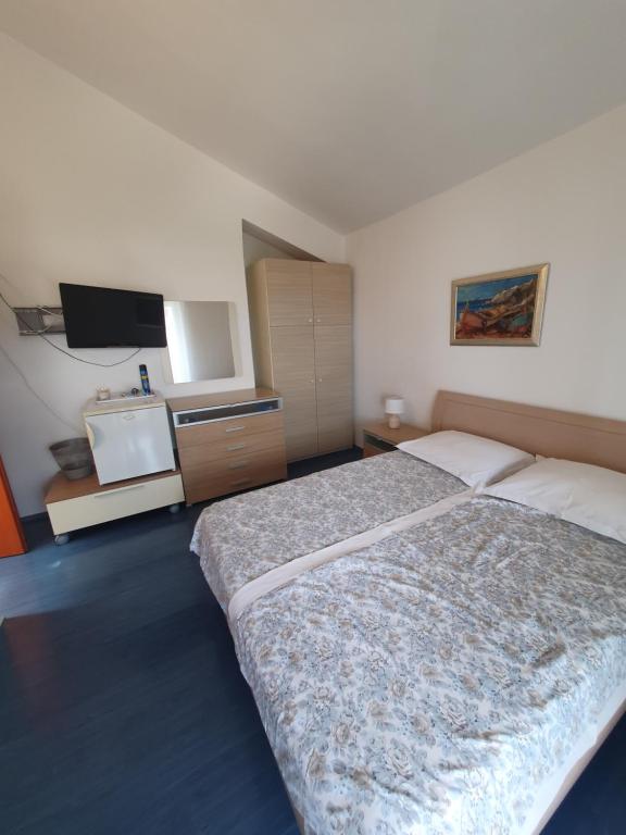 a bedroom with a bed and a flat screen tv at Marica Dedić in Barbat na Rabu