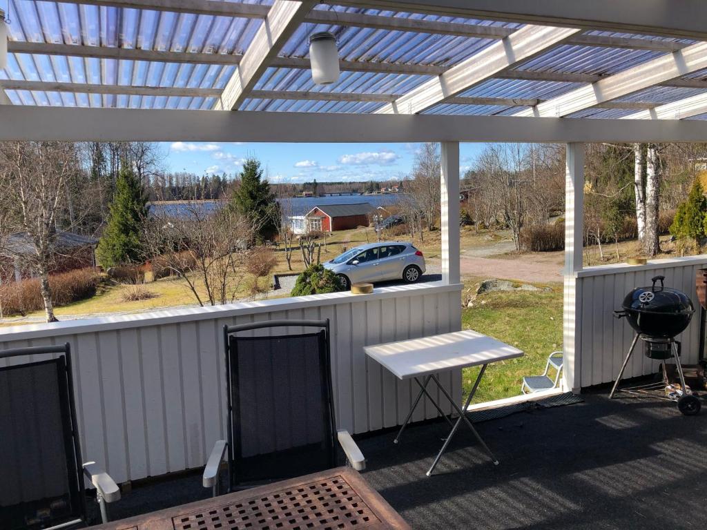 a patio with a white pergola and a grill at Magsjön in Surahammar