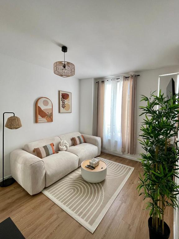 a living room with a couch and a table at Votre cocon parisien in Bagnolet