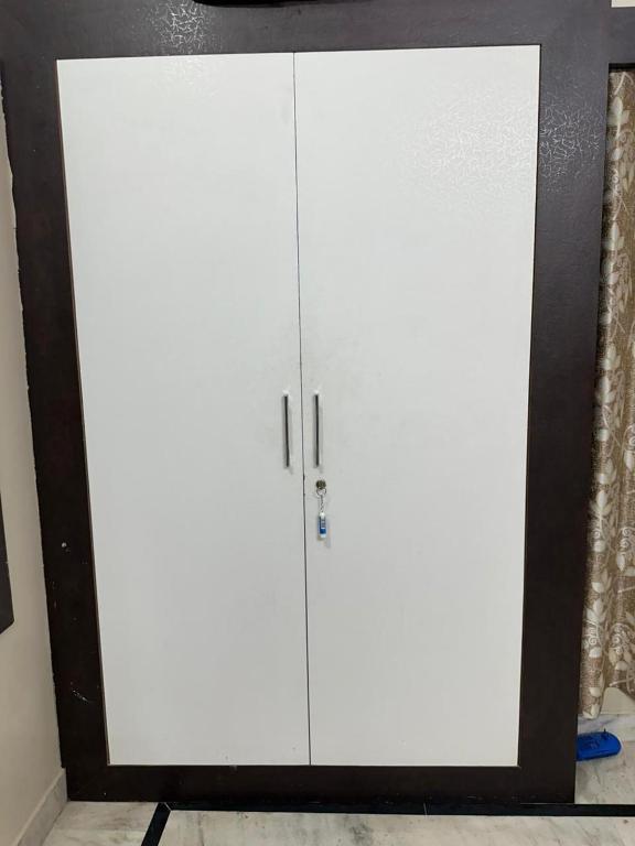 a white cabinet with two doors in a room at Dj's home stay in Jodhpur