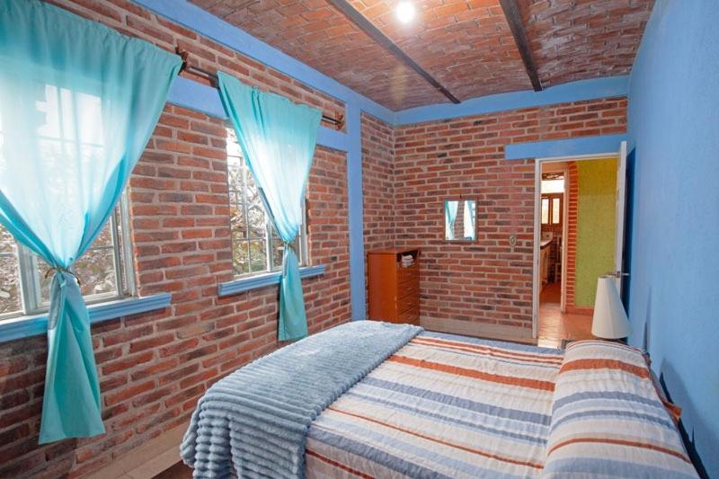a bedroom with a bed in a brick wall at Rancho alegre in Jocotepec