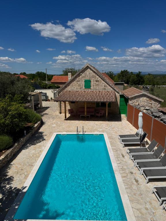 a swimming pool in front of a house at Rural house Mudrinic "Ivini dvori" in Bogatić
