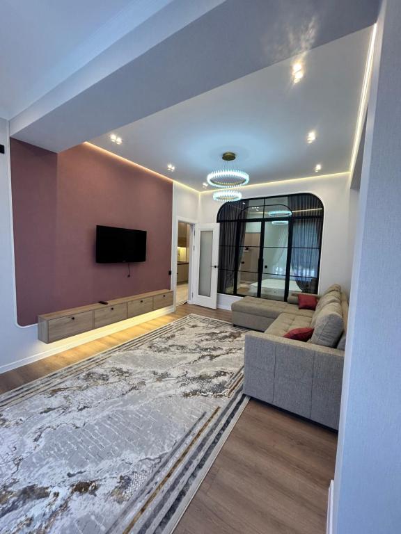 a living room with a couch and a flat screen tv at Lola in Osh