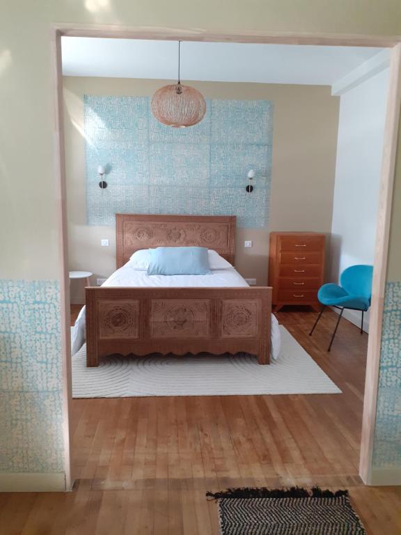 a bedroom with a bed and a blue wall at Les Chambres de Kérity in Penmarch