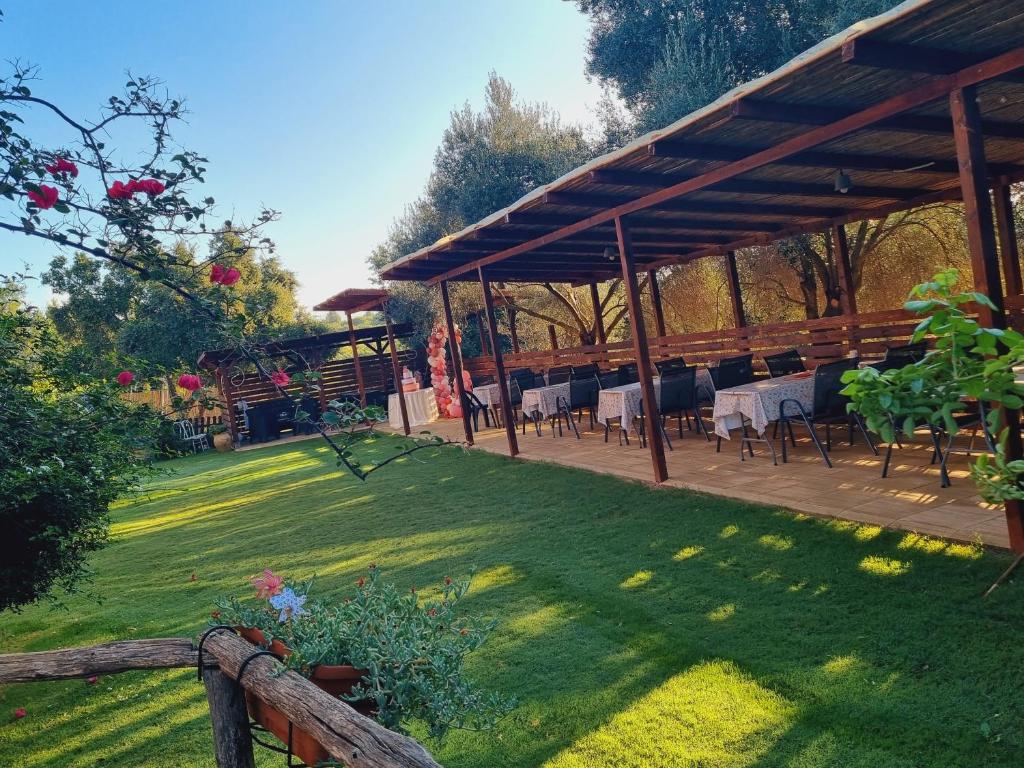a pavilion with tables and chairs in a garden at Agriturismo Punta Su Cunventu in Narcao