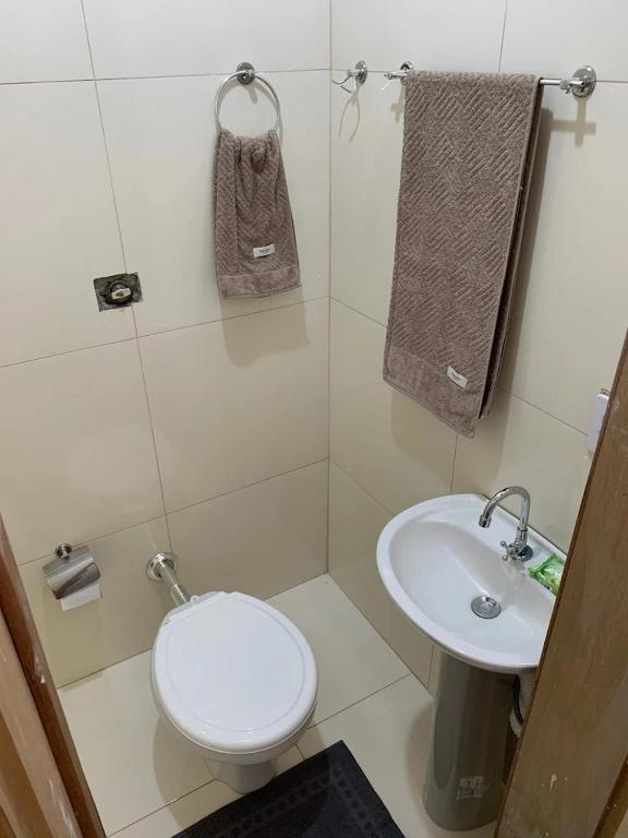 a bathroom with a toilet and a sink at Hotel Airton in Ivaiporã