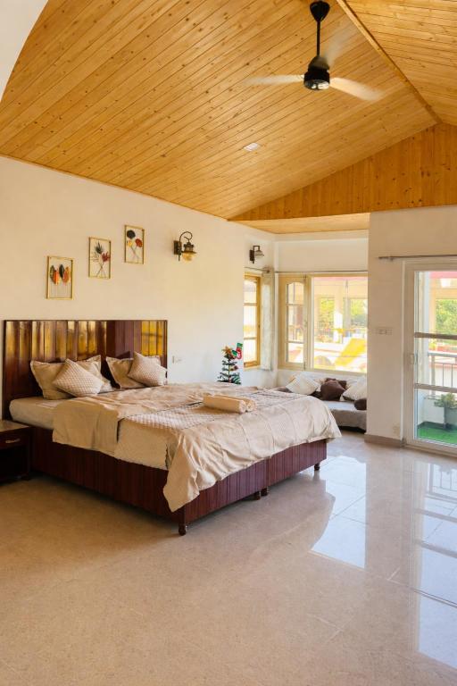 a bedroom with a large bed with a wooden ceiling at Sixtofifty Stays in Dharmsāla