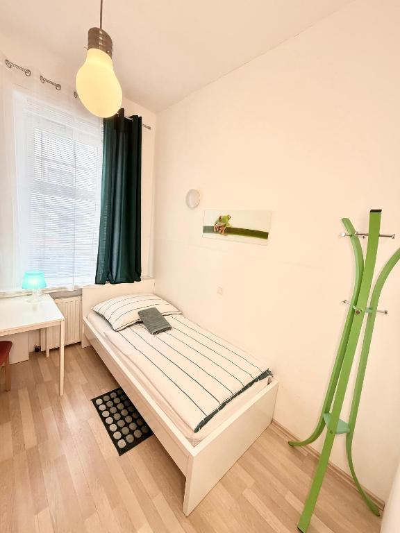a bedroom with a bed and a desk and a window at FAVORIT-ROOMS , direkt Metro connection U1 to Centralstation-Airport and City-Center in Vienna