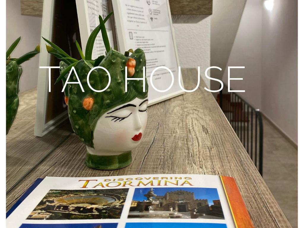 a vase on a table with a book and a magazine at Tao House in Taormina