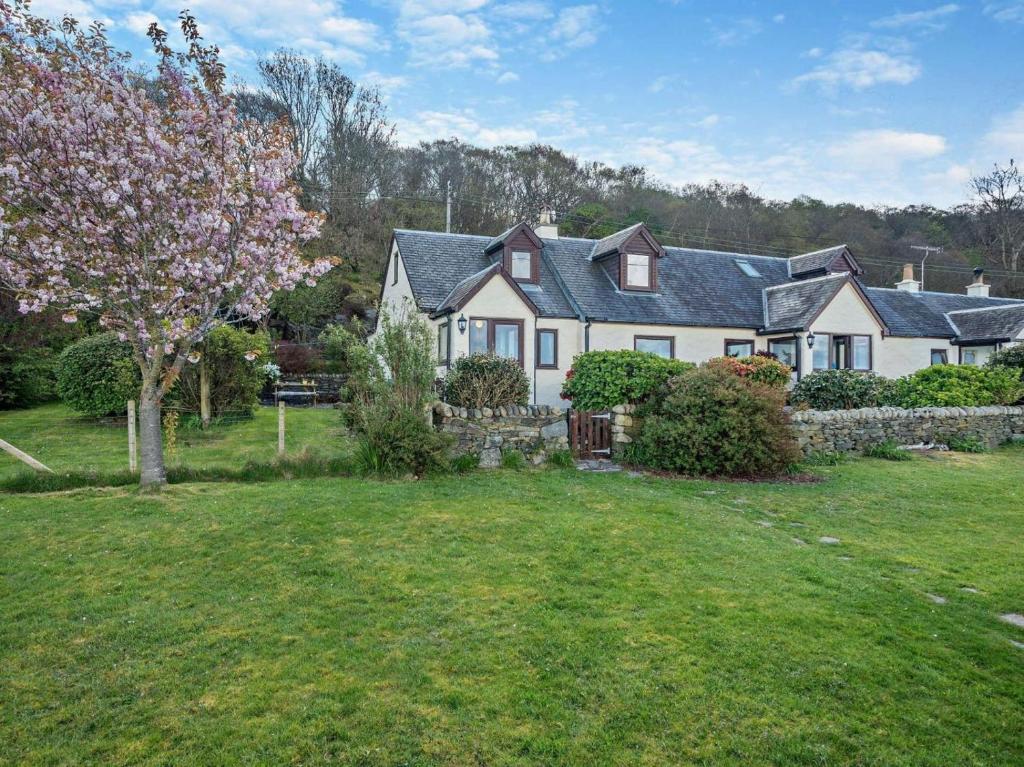 a large white house with a fence and a yard at 1 Bed in Isle Of Arran oc-ca272 in Pirnmill