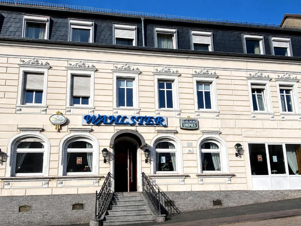 a white building with a blue sign on it at Hotel Wahlster in Saarbrücken