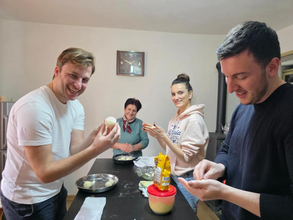 a group of people standing around a table eating food at Garden Home near Osum Canyon & Cooking Experience in Çorovodë