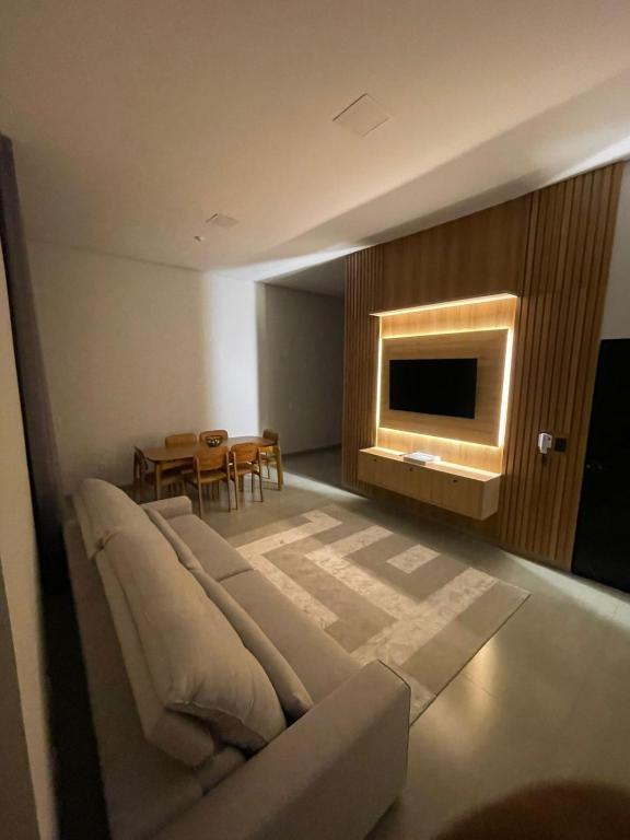 a living room with a couch and a television at Casa Alto Padrão 3 Quartos - Perto do Shopping Sinop in Sinop