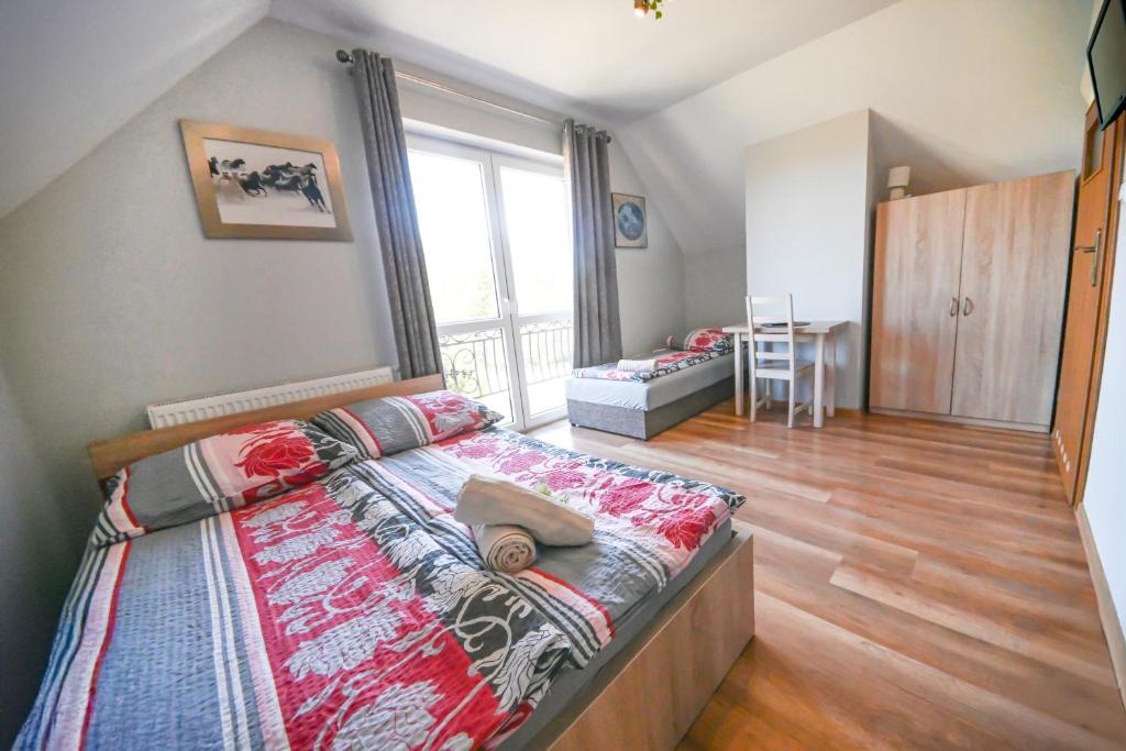 a bedroom with a large bed and a large window at Pod Stokiem in Lubomierz