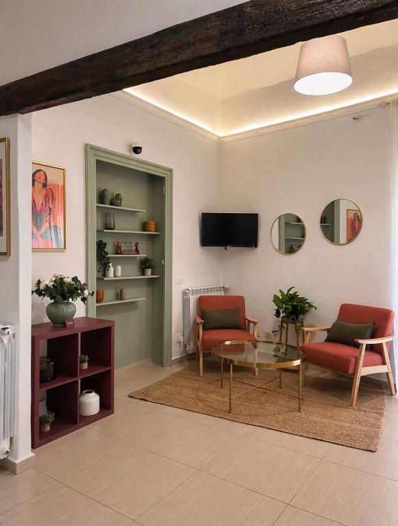 a living room with two chairs and a table at Atenè Rooms in Agrigento
