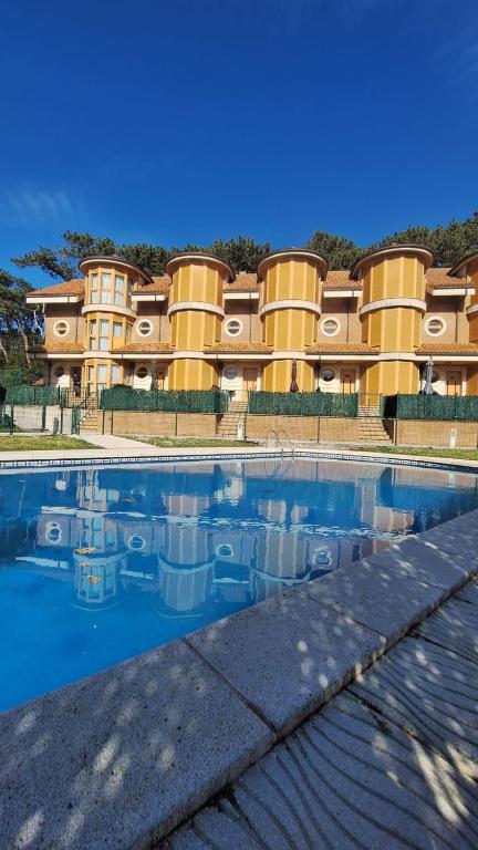 a building with a swimming pool in front of it at Enoturismo-Noja in Noja
