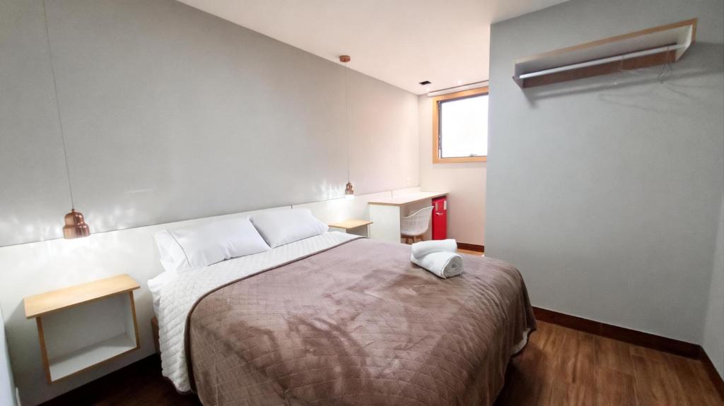 a bedroom with a large bed and a desk at Riviera Sanary Praia, Conforto e Tranquilidade in Serra