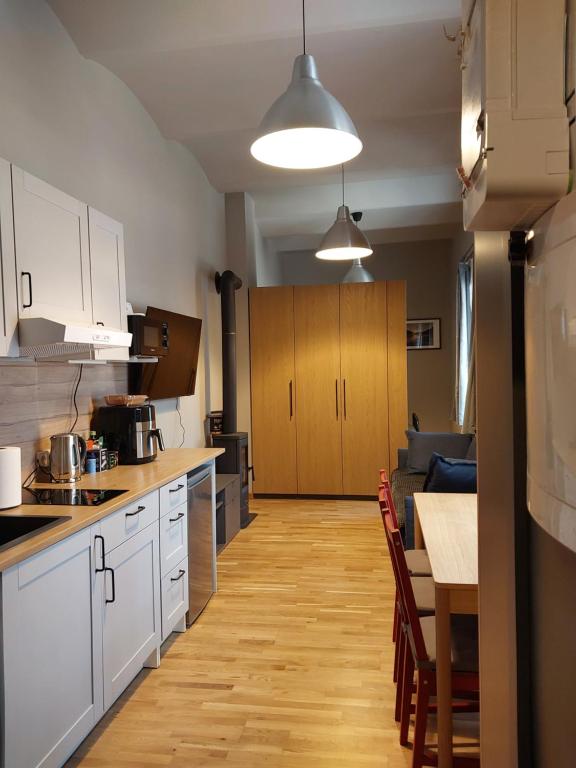 a kitchen with white cabinets and a table and a dining room at Robezu apartments 14 in Riga