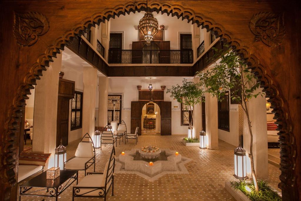 an archway in a building with chairs and a clock at Riad le Clos des Arts in Marrakech