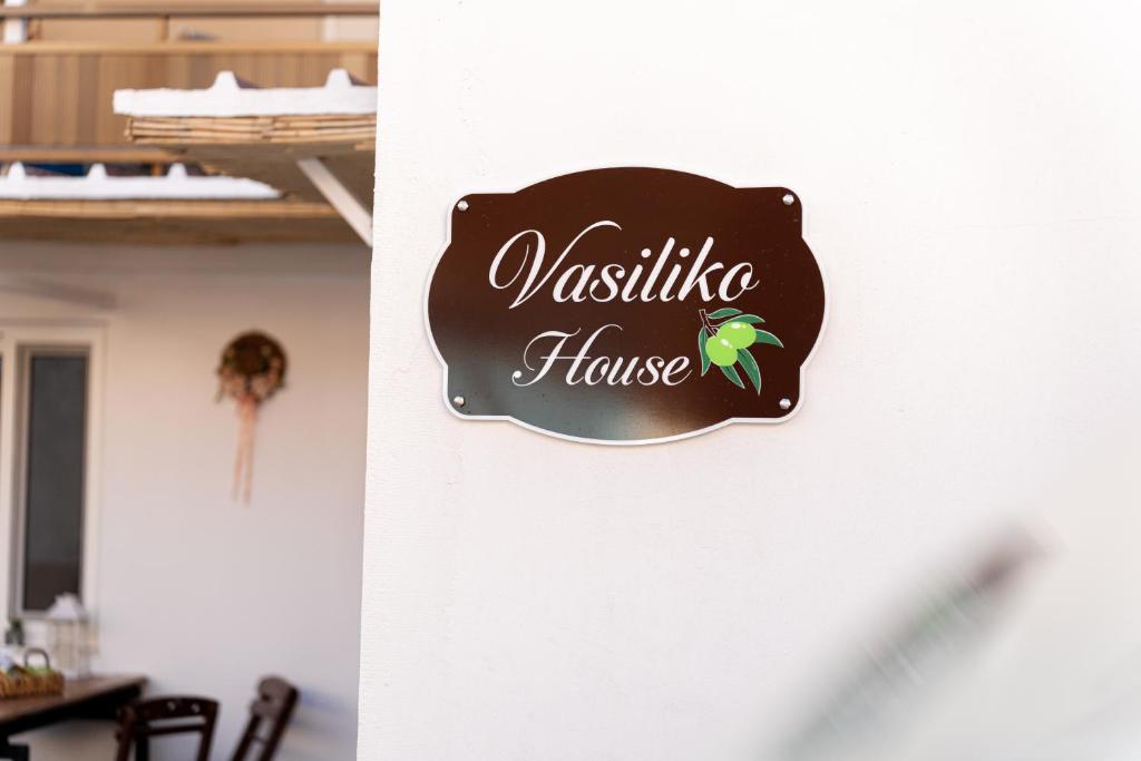 a sign for a house with a green bird on it at Vasiliko House in Kalavárda