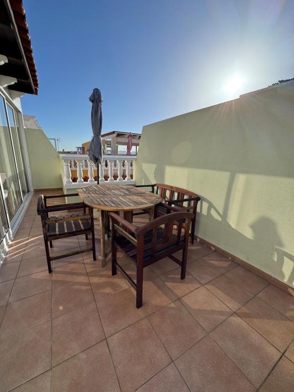 a table and two benches on a balcony at Olivia in Barrio-Mar
