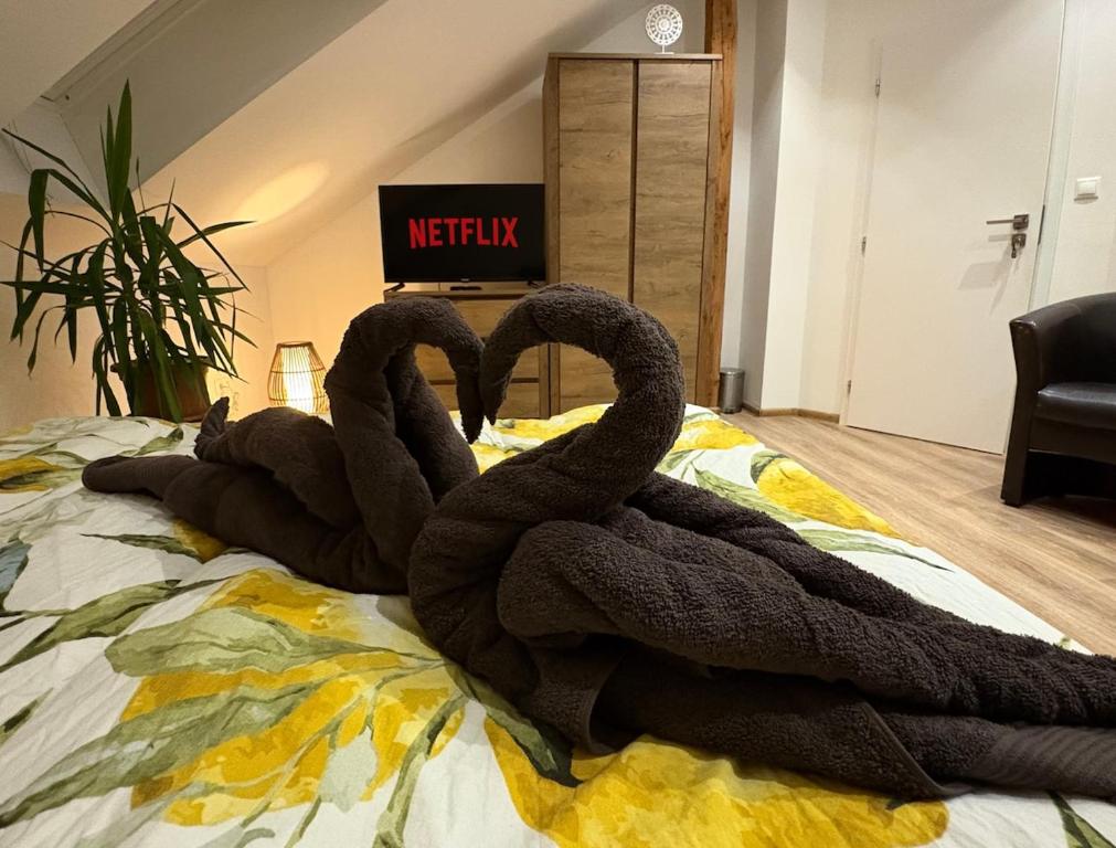 two black swans are sitting on a bed at Attic Apartment in Kočovce