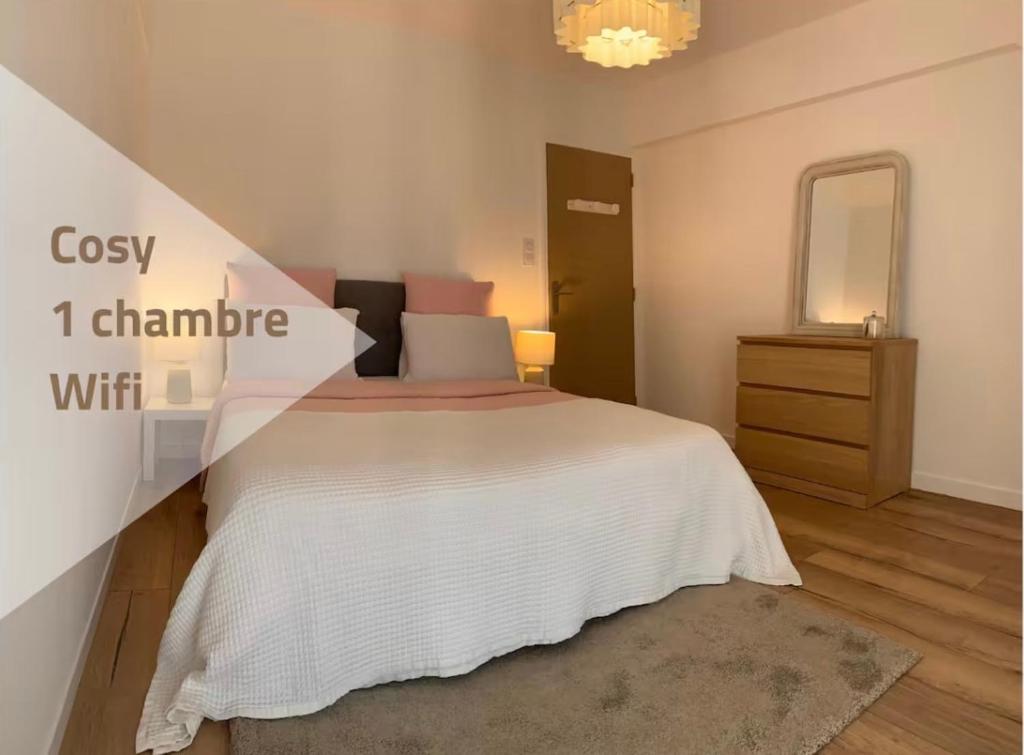 a bedroom with a large white bed and a dresser at Ourmes 1 Apartment in Guipry-Messac