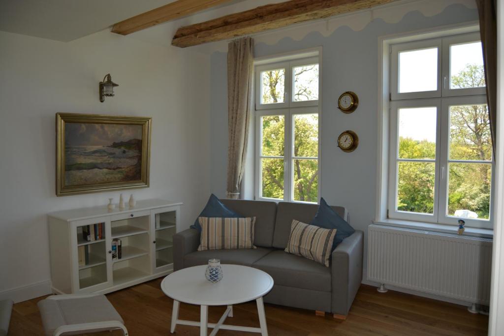 a living room with a couch and a table at Gutshaus Redentin in Krusenhagen