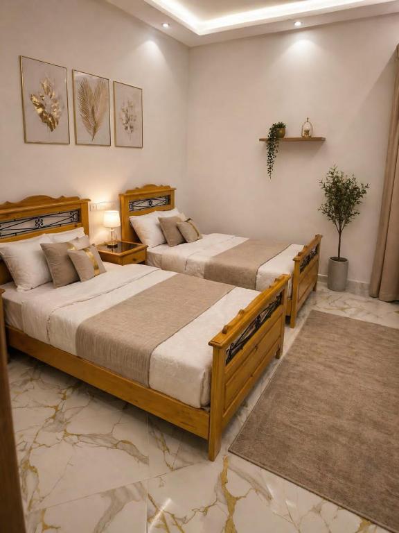 two beds in a room with two tables at Dalal house in Chefchaouen