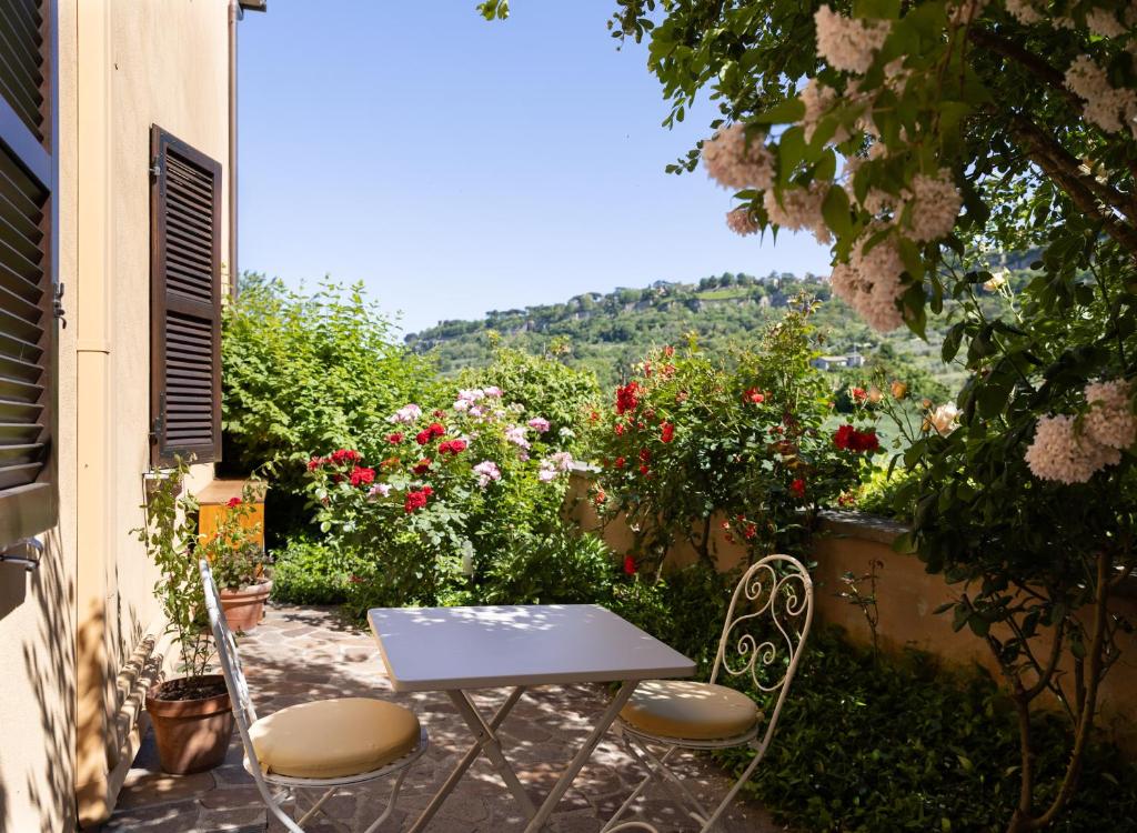 a table and chairs sitting on a patio with flowers at Casa Angolo delle Rose 2 in Orvieto