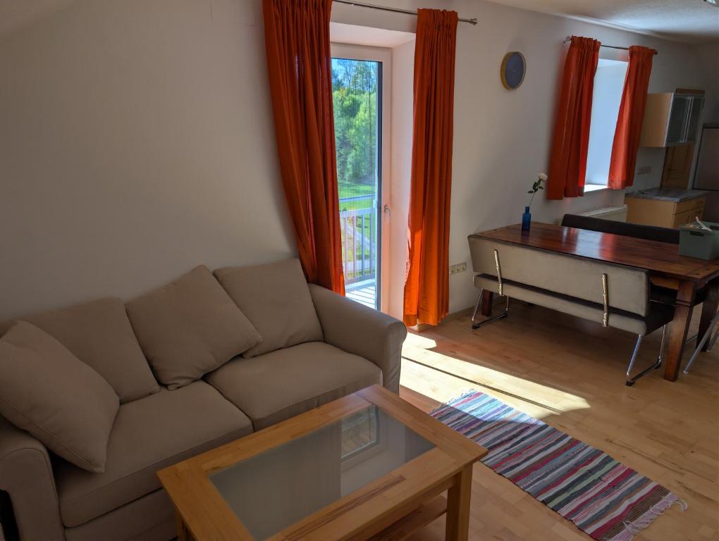 a living room with a couch and a piano at Ferienwohnung Weiding in Rutzenmoos
