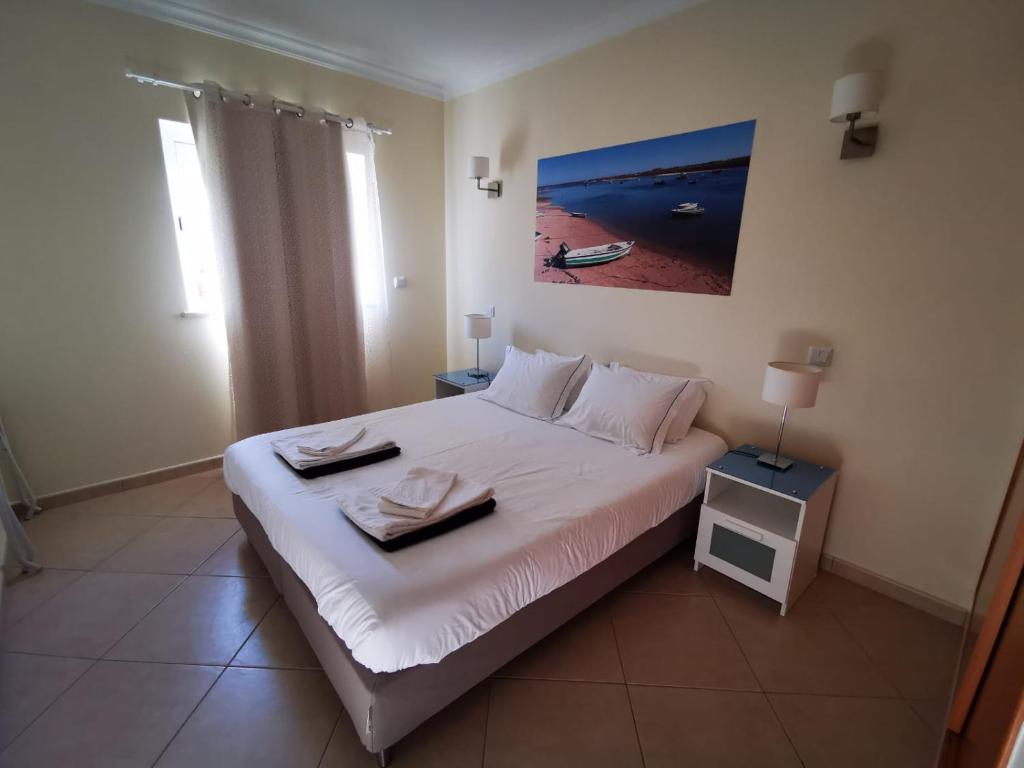 a bedroom with a bed with two towels on it at Cabanas Family Apartment in Cabanas de Tavira