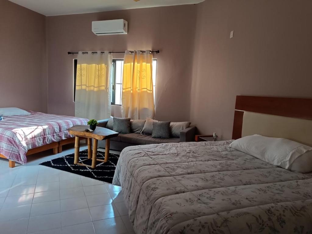 a bedroom with two beds and a couch at Finca la Esperanza in Guadalupe