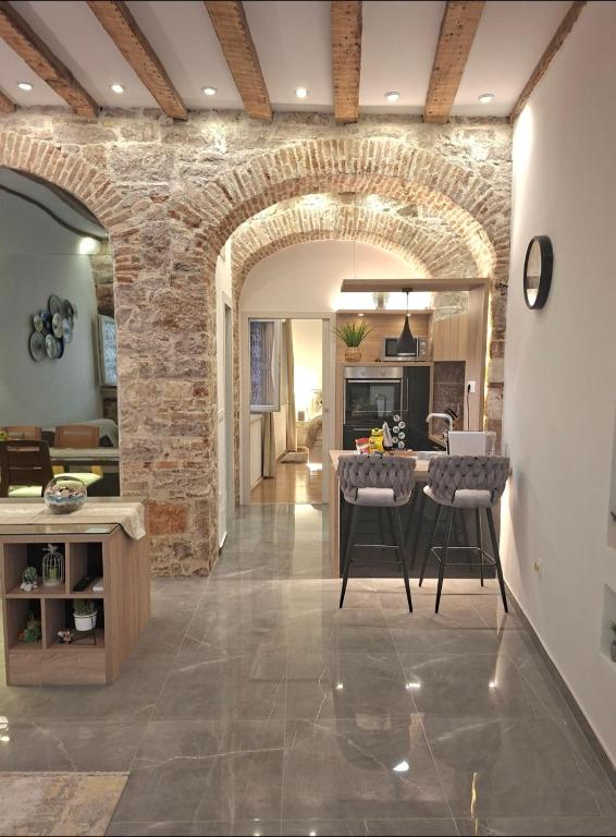 a kitchen and living room with a stone wall at Dalti Center Apartment in Zadar