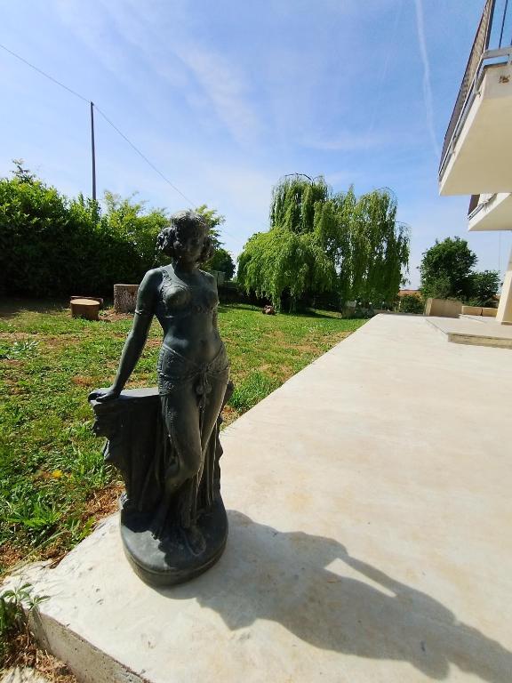 a statue of a woman standing on a sidewalk at I Quattro Venti in Pralormo
