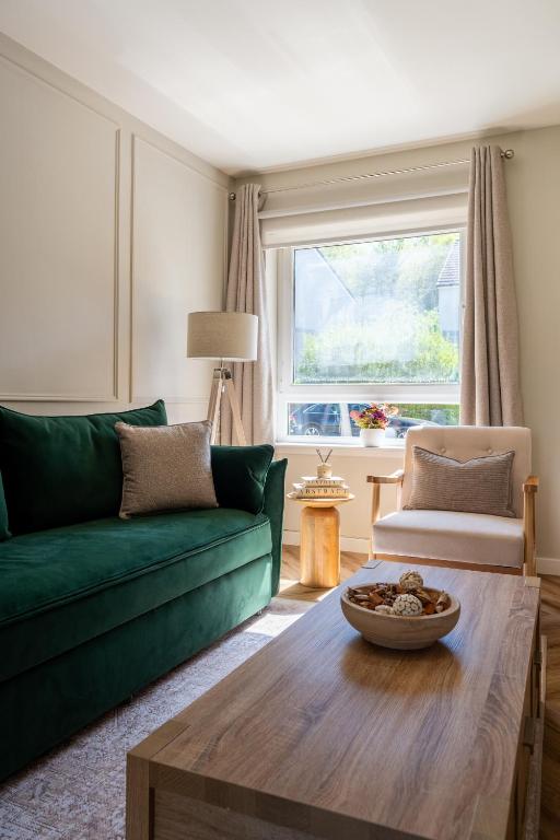 a living room with a green couch and a table at The Willows in Hurlet