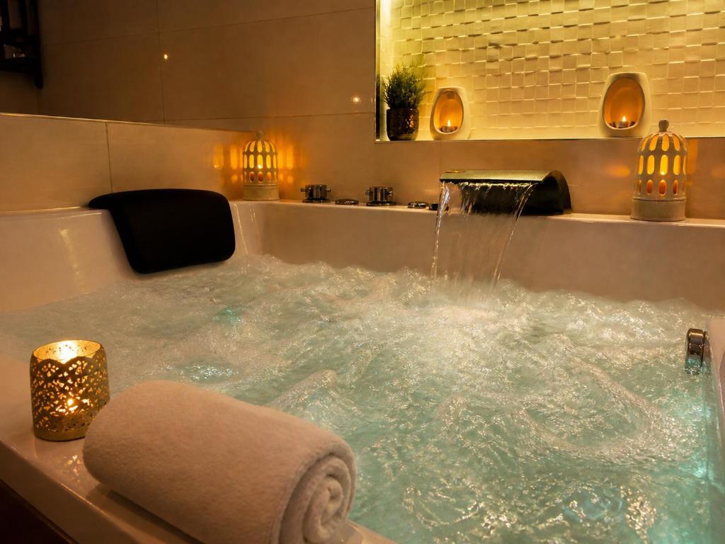 a bathroom with a jacuzzi tub filled with water at Appart' Spa et Sauna Privatif Au Cœur De Beaune in Beaune
