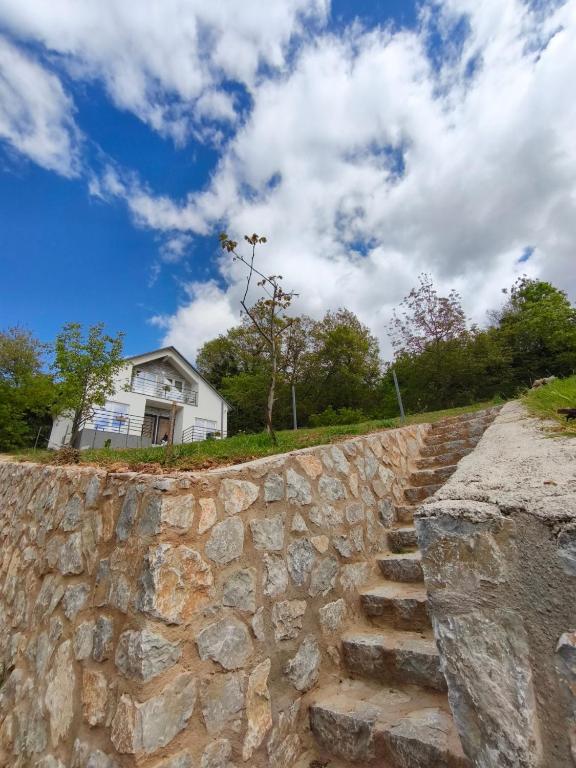 a stone wall next to a house and a building at Villa Hristina in Elshani
