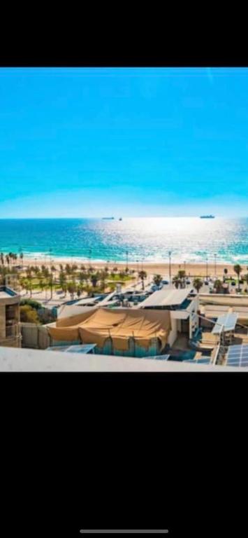 a beach with some umbrellas and the ocean at דירה על הים in Ashdod