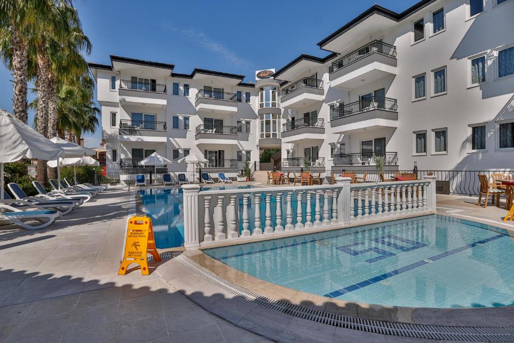 a swimming pool in front of a building at Adora Pansiyon in Side