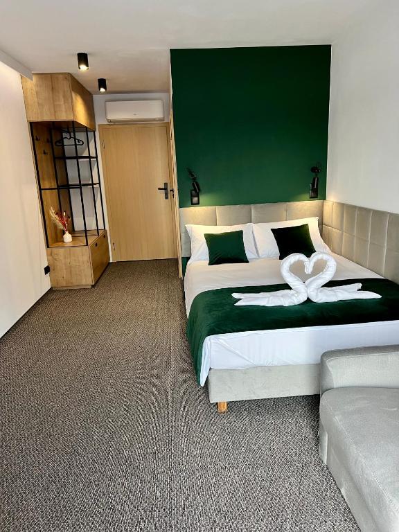 a bedroom with a large bed with a green headboard at Silence in Zator
