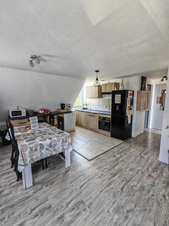 a kitchen and dining room with a table and a refrigerator at Gîte du logelbach in Wintzenheim