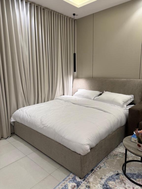 a bedroom with a large bed with white sheets at استوديو حي حطين in Riyadh