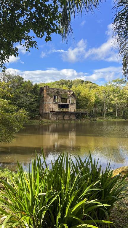an old house sitting in the middle of a lake at Sítio Mello in Igrejinha