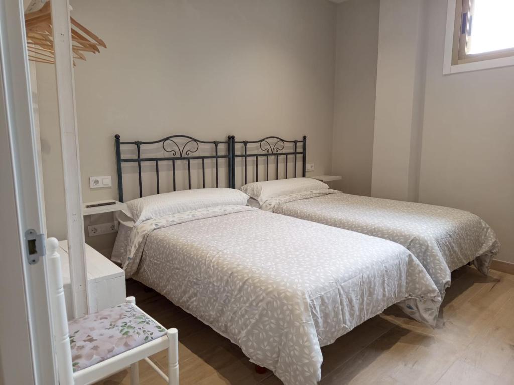 two beds in a small bedroom with a mirror at D'Canteira in Redondela