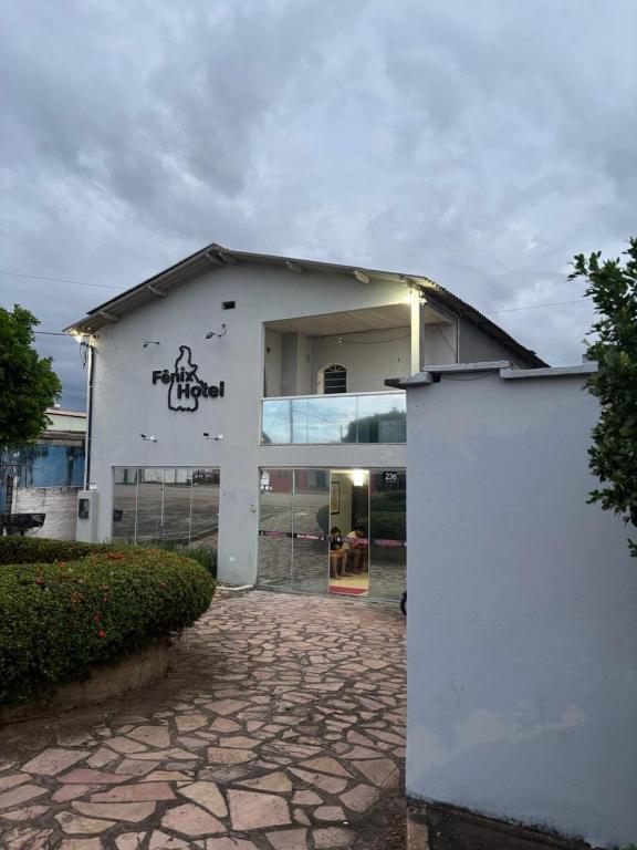 a white building with graffiti on the side of it at Fênix Hotel Colinas do Tocantins in Colinas do Tocantins