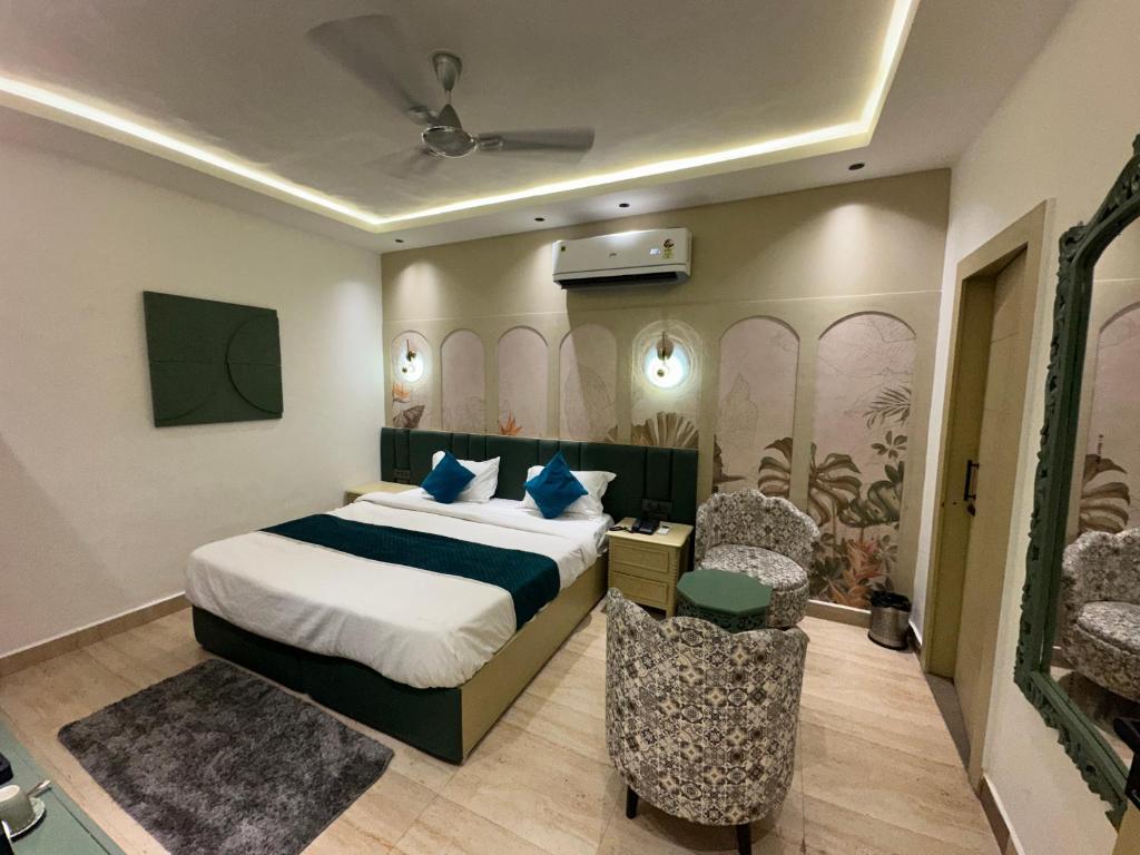 a hotel room with a bed and two chairs at Divine Hotel in Karnal