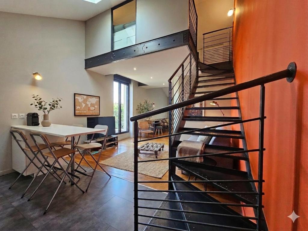 a spiral staircase in a home with a table and chairs at Le Loft de Genas centre Bourg in Genas