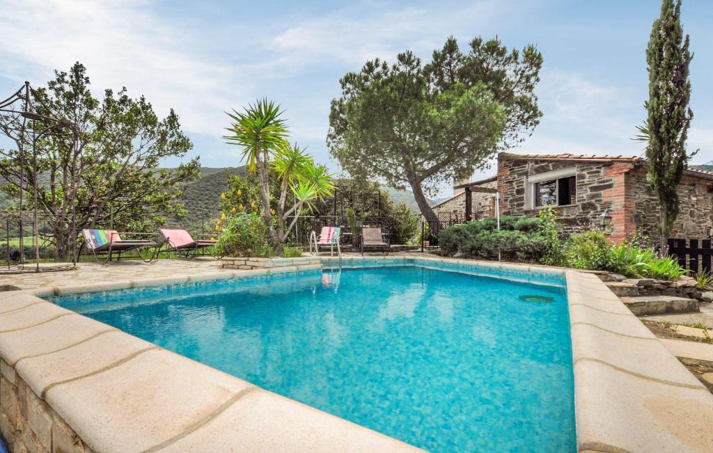 a swimming pool in front of a house at Awesome Home In Rigarda in Rigarda
