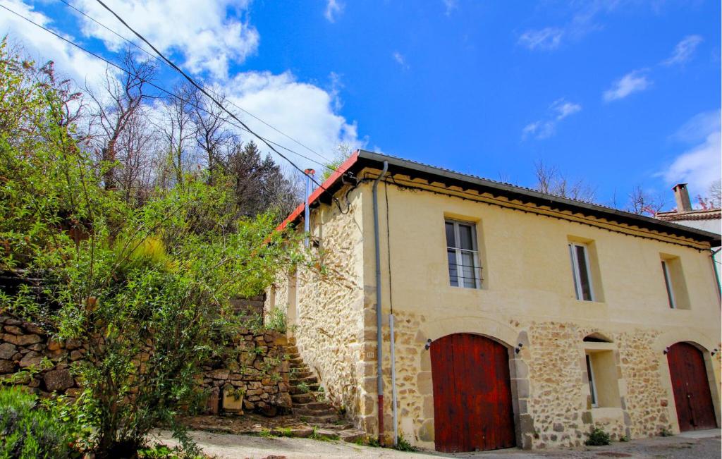 an old stone house with a red door at Mazet Du Gua in La Pervenche